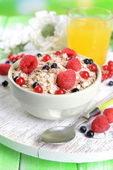 Tasty oatmeal with berries on table close-up