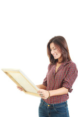 woman holding and looking at art painting in studio