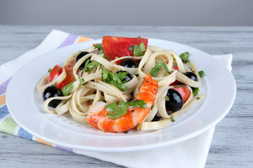 Fresh prawns with spaghetti, olives, tomatoes and parsley in a
