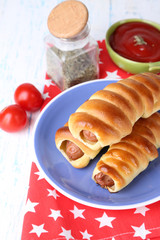 Baked sausage rolls on plate on table close-up