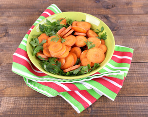 Slices of carrot, sorrel and parsley in green round bowl