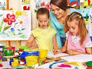 Children with teacher painting.