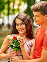 Couple with flower at park.