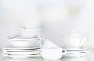 White crockery and kitchen utensils, on light background