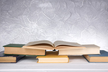 Books on wooden table on light background