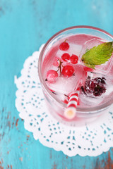 Cold cocktail with forest berries, frozen in ice cubes
