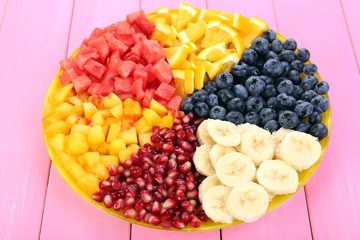 Sliced fruits on plate on wooden table