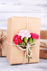 Beautiful gifts with flowers, on old wooden background