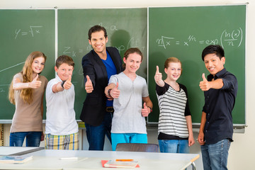 Lehrer mit Schülern in Schule vor Tafel
