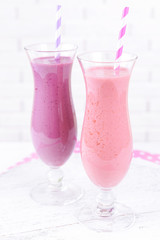 Delicious berry cocktails on table on brick wall background