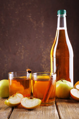 bottle of apple vinegar with fresh apples on wooden table