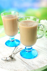 Delicious berry mousse in glasses on table on bright background