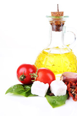 Sun dried tomatoes, feta cheese, olive oil in bottle and basil
