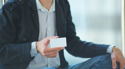 Man's hand showing business card