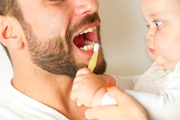 Baby hilft Papa beim Zähneputzen
