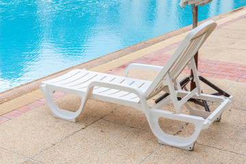 Beach chair near a blue swimming pool