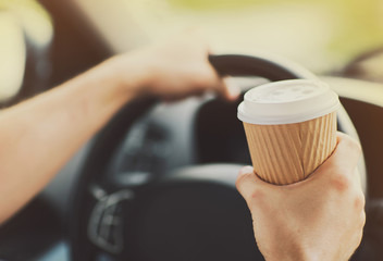 Fototapeta na wymiar man drinking coffee while driving the car