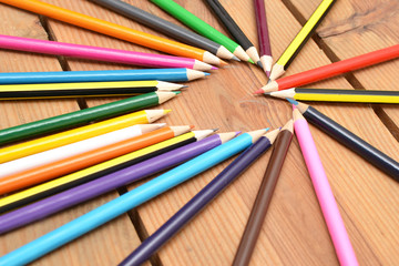 Naklejka premium Colored pencils on wood with heart form
