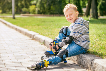 Little roller skater put on his skates