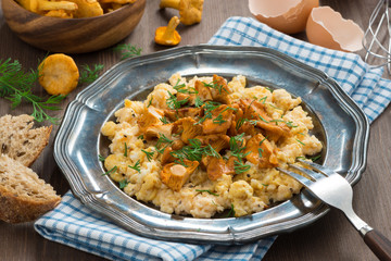 scrambled eggs with chanterelles and herbs on a plate
