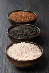 three kinds of rice in ceramic bowl on a dark background