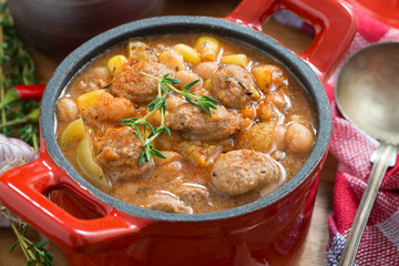 vegetable stew with sausages in a pan, close-up