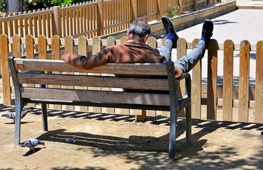 Älterer Mann schläft auf der Parkbankank