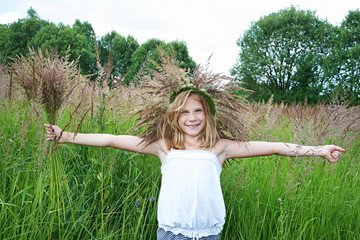 Girl in a wreath of grass with spikelets