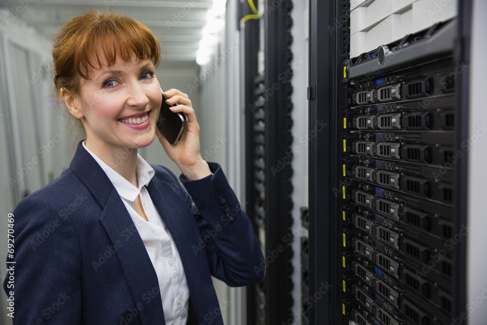 Aufkleber Smiling technician talking on phone while looking at server