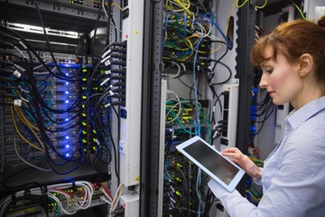 Technician using tablet pc while analysing server - Powered by Adobe