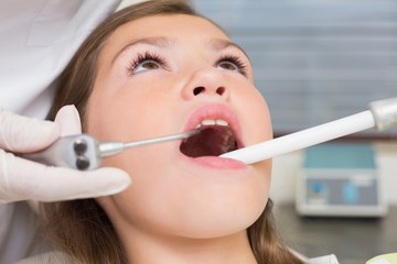 Dentist examining a girls teeth
