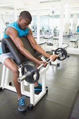 Fototapeta na wymiar Determined young man lifting barbell in gym
