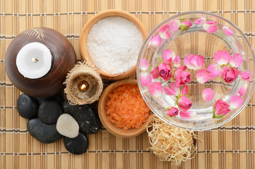 spa still life with candlestick, roses, stones and salt in woode
