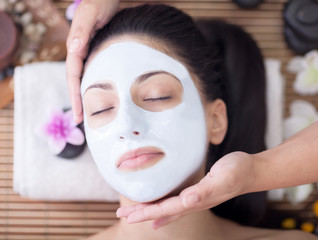   Spa therapy for young woman having facial mask at beauty salon