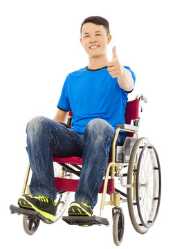 happy young man sitting on a wheelchair and thumb up