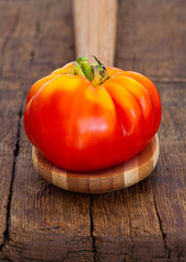 Reife Fleischtomate liegt auf Holzlöffel