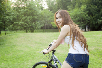 Fototapeta na wymiar Woman riding an exercise bike in the park.