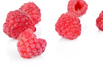 Many raspberries scattered on table isolated white background