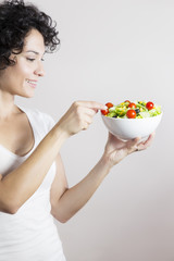 Young woman profile with vegetable salad isolated in white