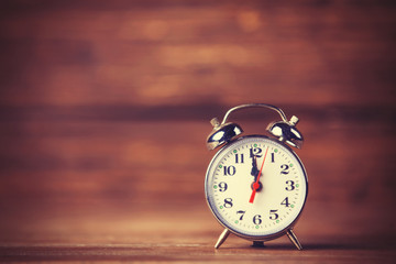 Retro alarm clock on wooden background