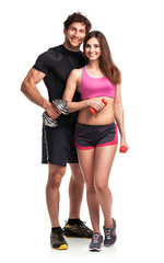 Athletic couple - man and woman with dumbbells on the white
