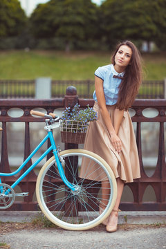 Young elegantly dressed woman with bicycle, summer and lifestyle