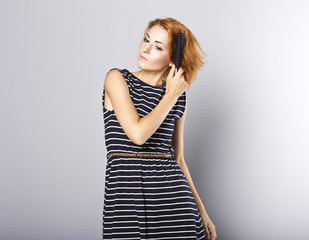 skinny redhead girl brushing her hair.