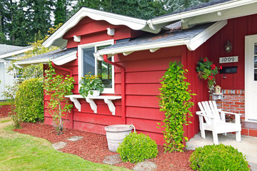 Fototapeta na wymiar Bright red house wall with white window