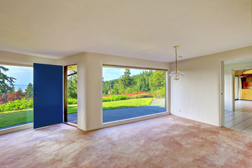Spacious empty living room. Glass wall and backyard landscape
