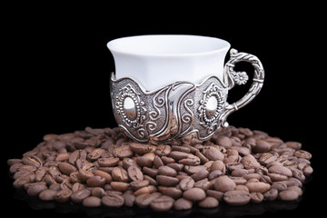 White cup with coffee beans  on black background