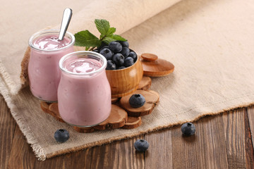 Obraz na płótnie Canvas yogurt with blueberries in a glass jar and blueberries in a wood
