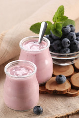 yogurt with blueberries in a glass jar and blueberries in a glas