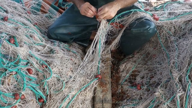 Fisherman cleans and prepares the fishing nets
