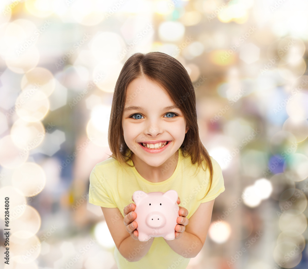 Wall mural beautiful little girl with piggy bank